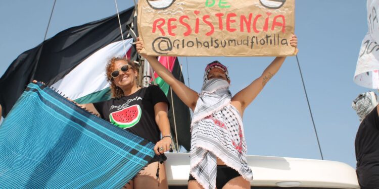Dos activistas muestran los carteles reivindicativos. / The Surge La Marea Ibiza.