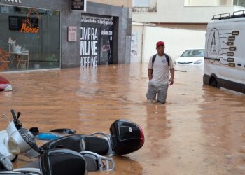 Un hombre atraviesa una calle con el agua hasta las rodillas. / D.V.