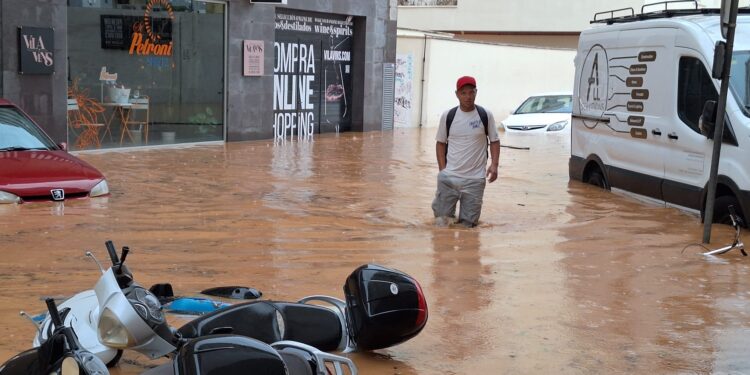 Un hombre atraviesa una calle con el agua hasta las rodillas. / D.V.