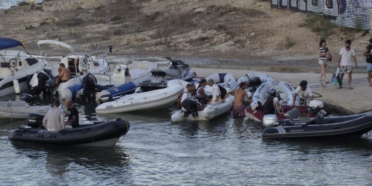 Barcas auxiliares de yates y chárters, apelotonadas ayer en el pequeño muelle de Talamanca después de que se haya cortado la baliza que puso el Consistorio para evitarlo y controlar la zona de baño. Foto de Noudiari.es