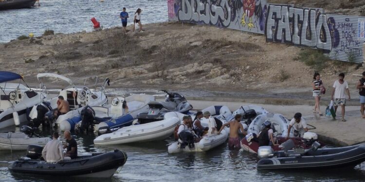 Barcas auxiliares de yates y chárters, apelotonadas ayer en el pequeño muelle de Talamanca después de que se haya cortado la baliza que puso el Consistorio para evitarlo y controlar la zona de baño. Foto de Noudiari.es
