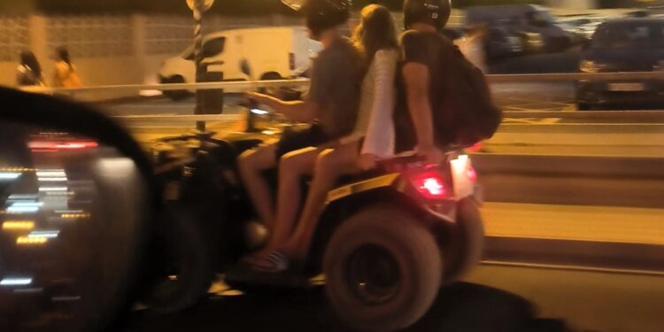 Imagen del quad con tres ocupantes, uno sin casco, en la Avenida de la Paz de Ibiza