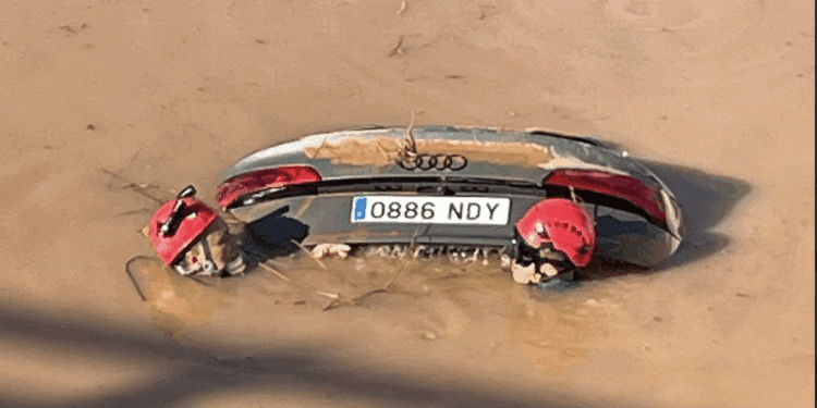 Dos agentes comprueban que no haya nadie dentro del vehículo hundido en esta impresionante imagen de la Guardia Civil.
