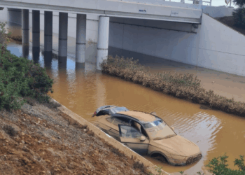 Un coche ha aparecido en la carretera del aeropuerto, anegada, tras achicar el agua.