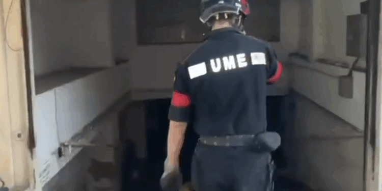 Un miembro de la UME actúa en el garaje del edificio Cabiro, en la calle diputat Josep Ribas, que ha estado cerrada.