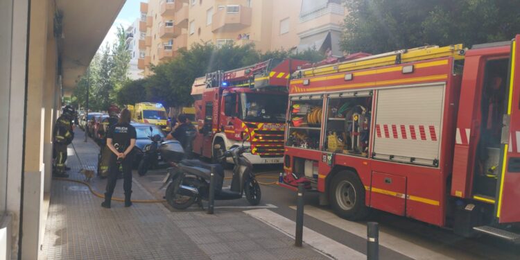 Los bomberos, en el momento en el que han rescatado a un perro que se había quedado en la vivienda incendiada. Fotos V. R. Noudiari.es