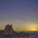 Clicka sobre la imagen de Paco Natera para verla al completo. El fotógrafo ha captado al cometa Lemmon (C/2025 A6) surcando el cielo estrellado sobre Es Vedrà, como se aprecia en la derecha de la imagen. Fotografía Paco Natera.
