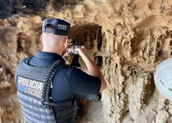 Un policía documenta los hallazgos en la cueva del litoral, que han inspeccionado en coordinación con la Guardia Civil.