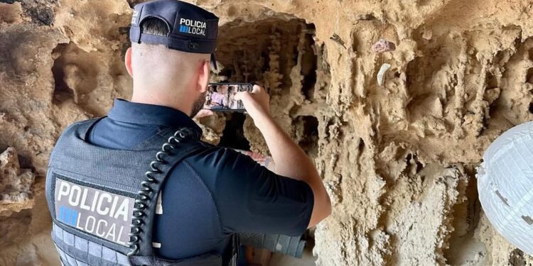 Un policía documenta los hallazgos en la cueva del litoral, que han inspeccionado en coordinación con la Guardia Civil.
