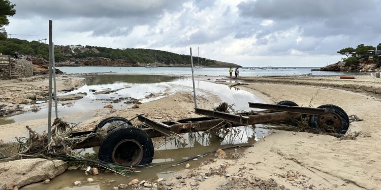 Un gran remolque arrastrado por la fuerza de la riada de ayer, que ha quedado en mitad de la playa de s'Arenal Gros de Portinatx, convertida en un río y parcialmente anegada. Fotos Noudiari L. F. A.