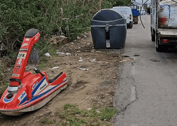 Imagen de la moto abandonada junto a uno contenedores