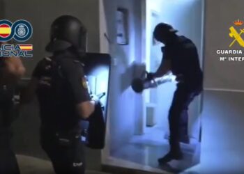 Momento en el que los agentes derriban la puerta de uno de los domicilios de la banda criminal. / GC-PN