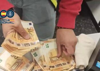 Contando billetes incautados en la caravana. Imagen de la Policía Nacional.