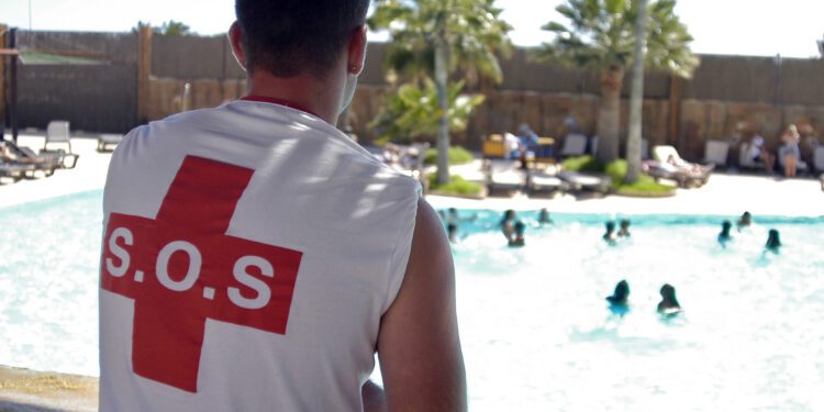 Un socorrista observa a unos bañistas en una piscina. Foto CC BY-NC-SA 2.0.