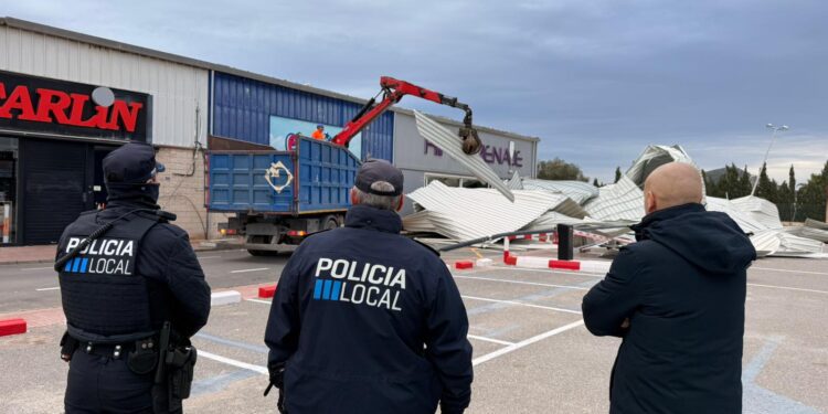 El concejal de Ibiza, Jordi Grivé, observa la retirada de las planchas, acompañado por dos policías locales.