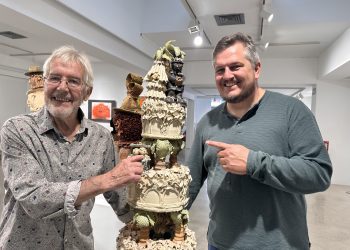 El artista Gerry Clark y su hijo, el poeta Ben Clark, junto a una obra de Gerry, de 1991, que representa el pastel de bodas de su enlace con Elaine Clark. Foto Noudiari.es