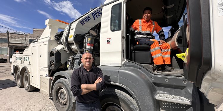 Paco de la Cruz, junto a la grúa más potente de Grúas Ibiza, en la que está Walter, uno de los empleados. Fotos Noudiari