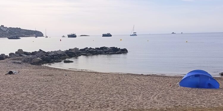 Unas personas durmiendo en una tienda de campaña en la playa y otra pernoctando sobre la arena a pocos metros el domingo 14 de junio. Foto C. R. Cedida a Noudiari