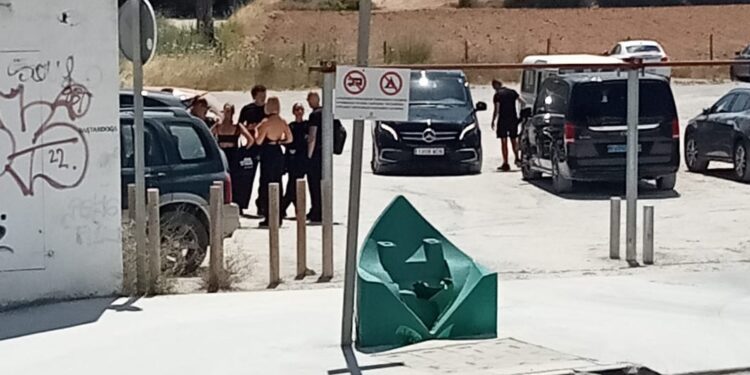 Aparcamiento del CEIP L'Urgell con varias personas dejando sus vehículos y furgonetas negras. Foto de Noudiari.es