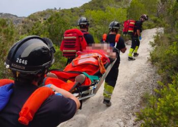 Los bomberos portean a la mujer rescatada en el camino a Es Portitxol.
