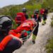 Los bomberos portean a la mujer rescatada en el camino a Es Portitxol.
