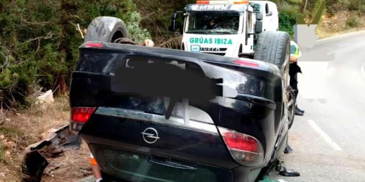 El vehículo volcado mientras estaba siendo retirado por una grúa pluma de Grúas Ibiza.