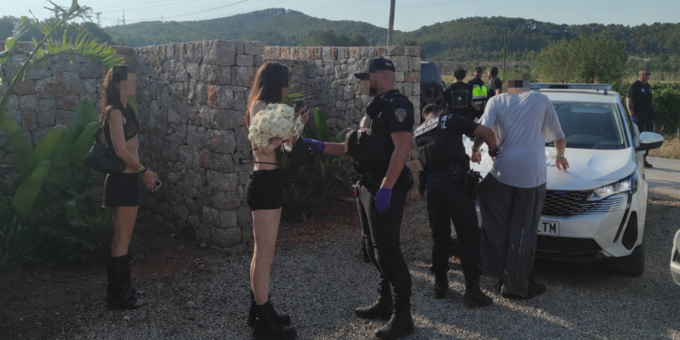 La Policía Local de Santa Gertrudis registra a asistentes a la fiesta.