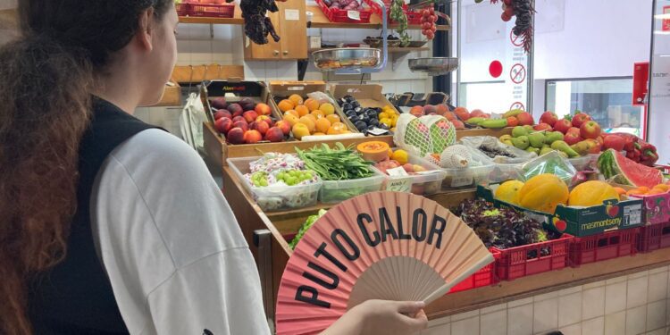 Una paradista del Mercat se abanica al calor del ambiente. Foto: Noudiari