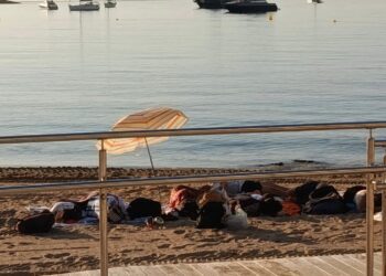Personas pernoctando hoy en la playa de Ses Figueretes de Ibiza a primera hora de la mañana. Foto Noudiari.es
