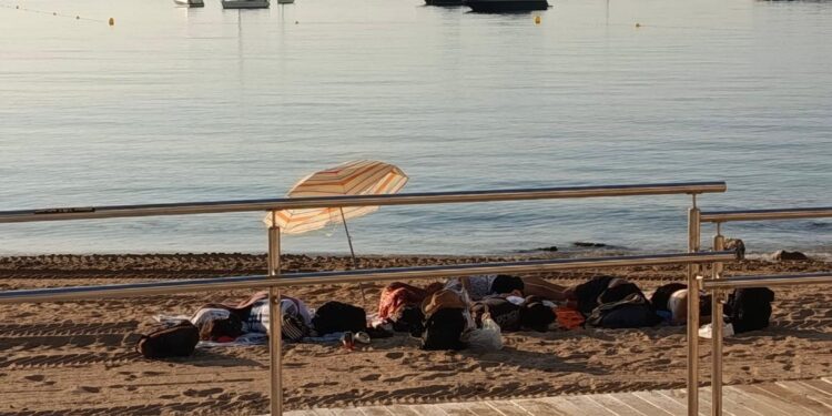 Personas pernoctando hoy en la playa de Ses Figueretes de Ibiza a primera hora de la mañana. Foto Noudiari.es