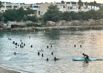 Personas a remojo a principios de este mes en Port des Torrent tras la puesta de sol. Foto Noudiari