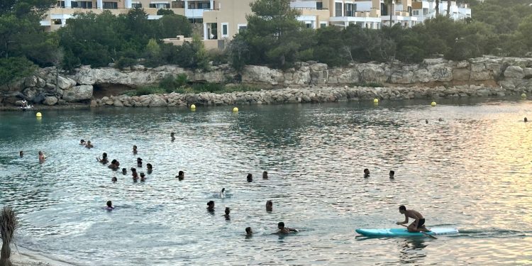 Personas a remojo a principios de este mes en Port des Torrent tras la puesta de sol. Foto Noudiari