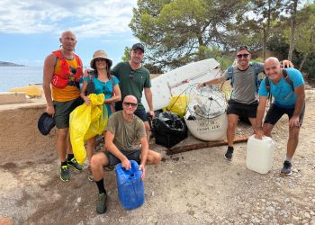 Voluntarios y voluntarias posan delante de toda la basura retirada durante la jornada de limpieza litoral en Sant Josep. Imagen de Trekking Ibiza cedida a Noudiari