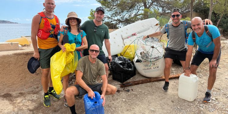 Voluntarios y voluntarias posan delante de toda la basura retirada durante la jornada de limpieza litoral en Sant Josep. Imagen de Trekking Ibiza cedida a Noudiari