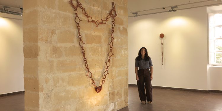 Neus Riera, Riqueta, junto a algunas de las obras que se expondrán en el Far de ses Coves Blanques. Imagen cortesía de la artista.