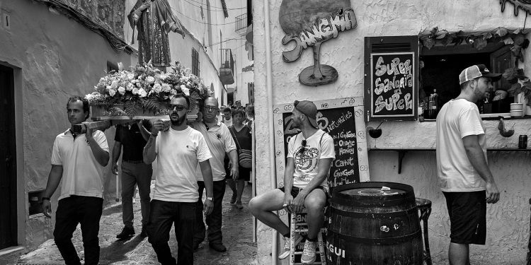 Una imagen del contraste entre la sociedad tradicional ibicenca y la del turismo, que confluyen en Dalt Vila,